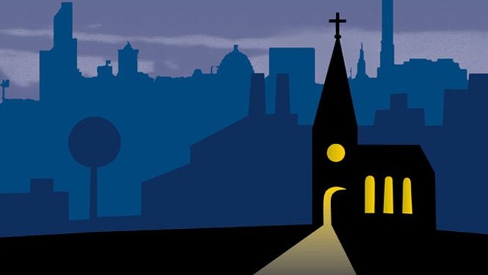 Eine Kirche steht vor einer Stadt bei Nacht