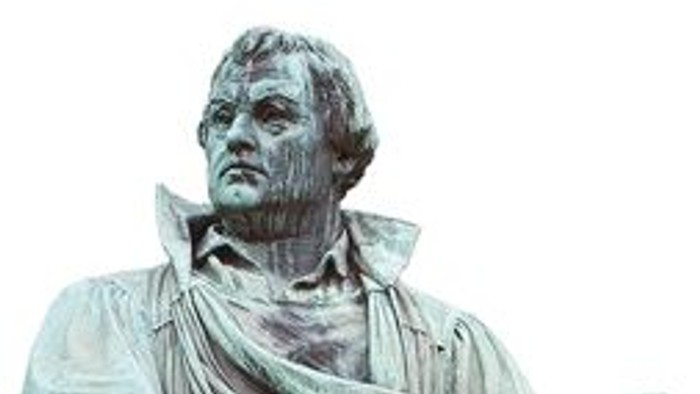 Die Statue eines Mannes mit Buch und Umhang.