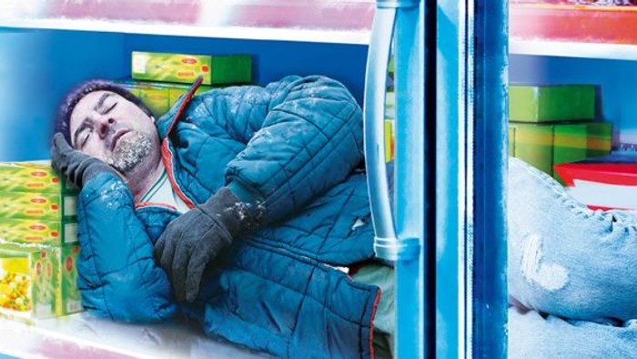 Mann schläft in einem Kühlregal eines Supermarkts.