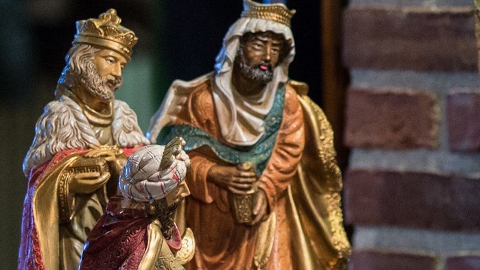 To statuer af konger med kroner og lange kapper, en holder en lille figur.