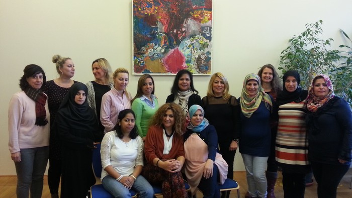 Ein Gruppenfoto von Frauen vor einem farbenfrohen Gemälde