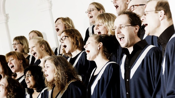 En kor med mænd og kvinder, der synger med glæde