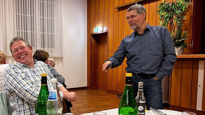 Zwei Männer bei einem Essen mit Wein und Wasserflaschen auf dem Tisch