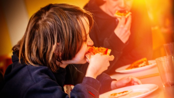 Børn spiser pizza i restaurant