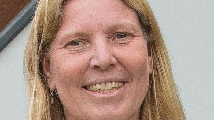 Eine Frau mit blondem Haar lächelt in die Kamera.