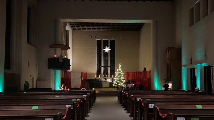 Weiter Blick in die weihnachtlich beleuchtete Kirche mit Weihnachtsbaum