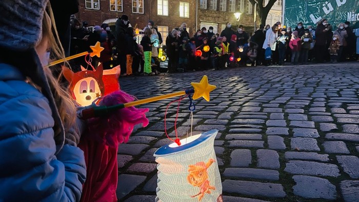 Menschen bei Nachtfest mit Laternen auf Kopfsteinpflasterstraße
