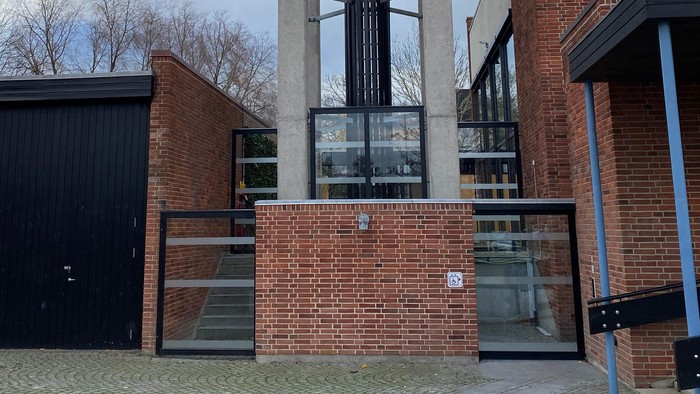 Moderne kirke med høj klokketårn og røde mursten