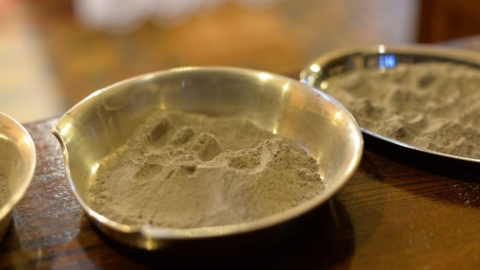 Zwei silberne Schalen mit Pulver auf einem Holztisch