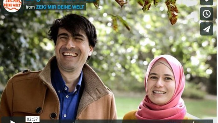 Ein Mann und eine Frau in bunter Kleidung lachen im Freien.