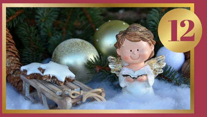 Engelfigur mit Weihnachtsbaumschmuck und Schlitten im Schnee