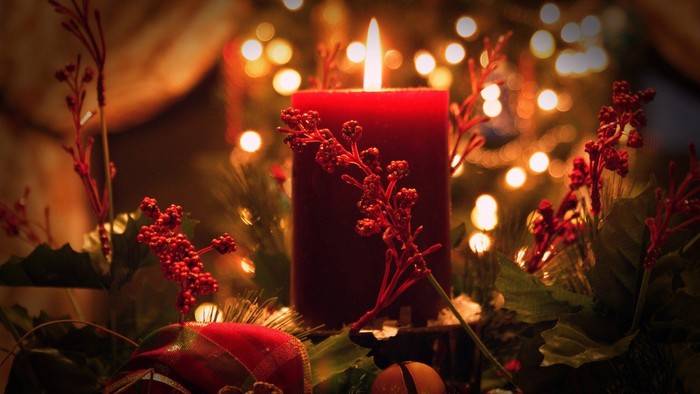 Weihnachtliche Dekoration mit brennender Kerze und Lichtern