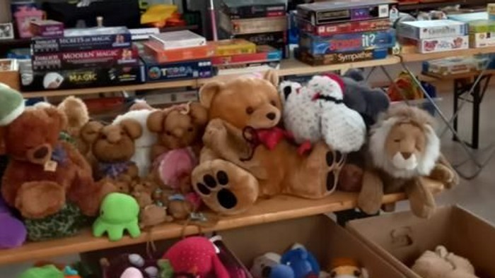 Viele Spielzeuge und Bücher in Kisten und Regalen