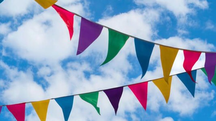 Bunte Fähnchen im blauen Himmel mit weißen Wolken