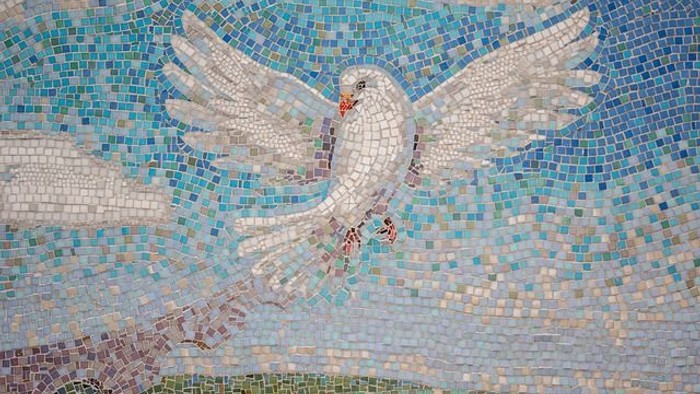 Das Mosaik zeigt zwei fliegende Tauben vor blauem Hintergrund