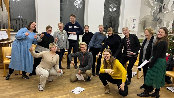 En gruppe af mennesker poser til et foto i et rum med juledekorationen.