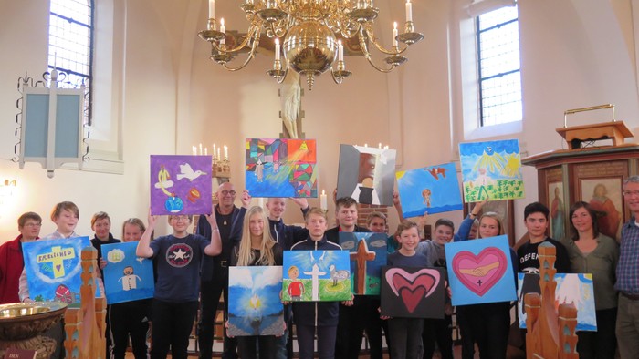 En gruppe af mennesker holder op med malerier i en kirke