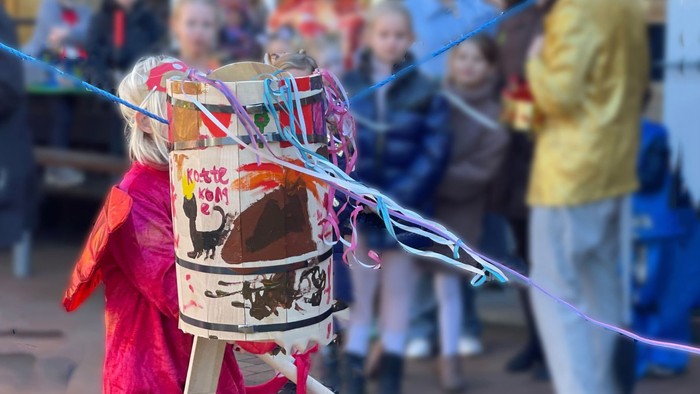 Barn med masker og farver på gadefest