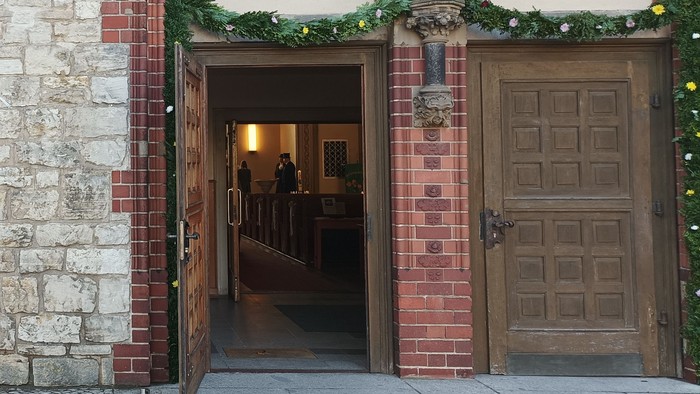 Jubiläumsbanner an historischem Gebäude mit Rundbogenportal