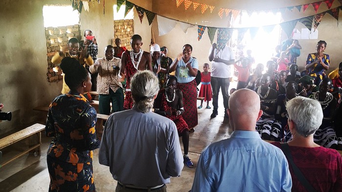 Gruppe von Menschen in einem Raum mit Holzbalken und bunten Bändern