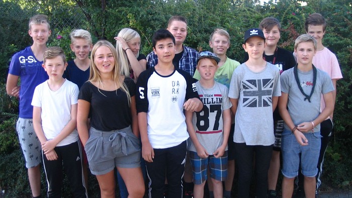 En gruppe unge og voksne poserer sammen udendørs