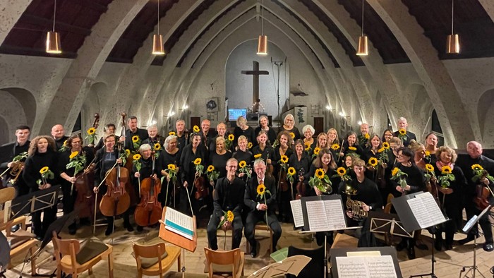 Ein großer Chor und Orchester proben in einer Kirche