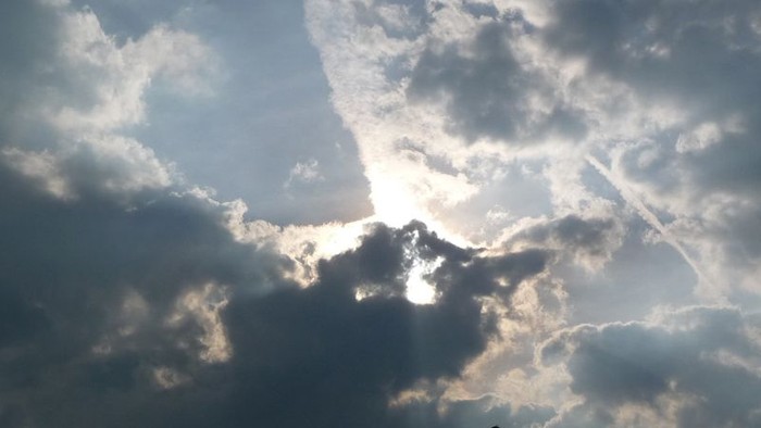 Silhouetten von Menschen vor dramatischem Himmel