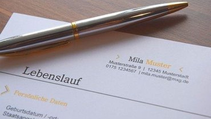 Ein Stift liegt auf einem teilweise ausgefüllten deutschen Lebenslauf mit persönlichen Kontaktdaten, der mit „Lebenslauf“ beschriftet ist.