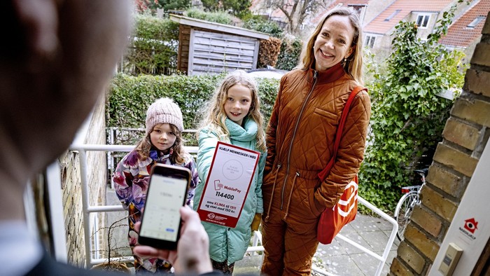 En kvinde og to børn tager selfie på trinbræt med telefon.