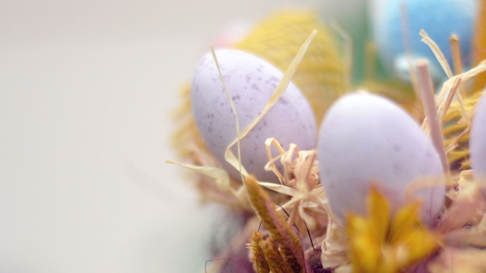 Bunte Ostereier in einem Korb mit Blumen