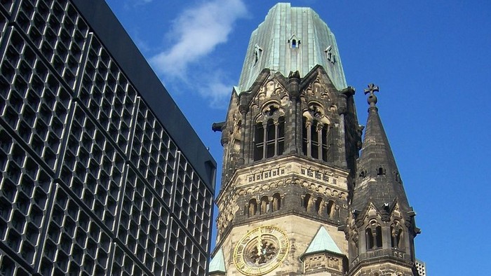 Altes Gebäude mit Uhr und moderner Architektur im Hintergrund