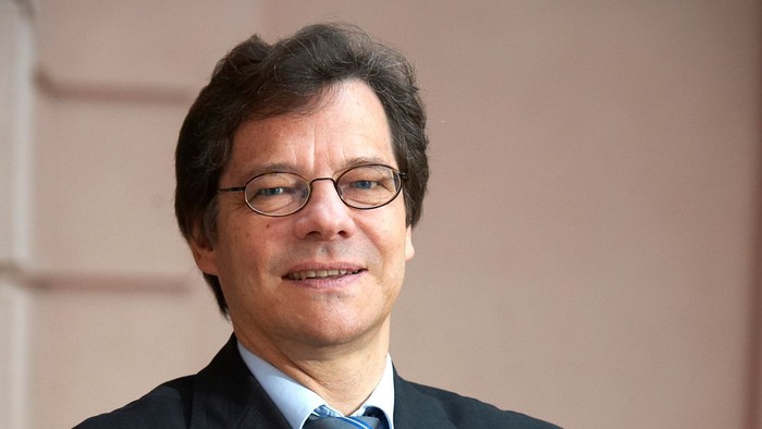 Mann mit Brille und Krawatte lächelt in die Kamera