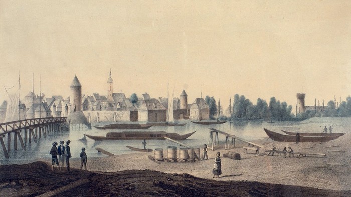 Das Bild zeigt eine historische Flusslandschaft mit Booten und Gebäuden.