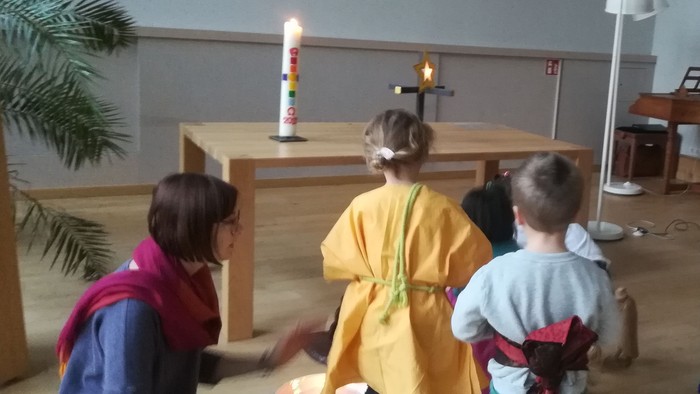Kinder in Kirche mit Kerze und Frau