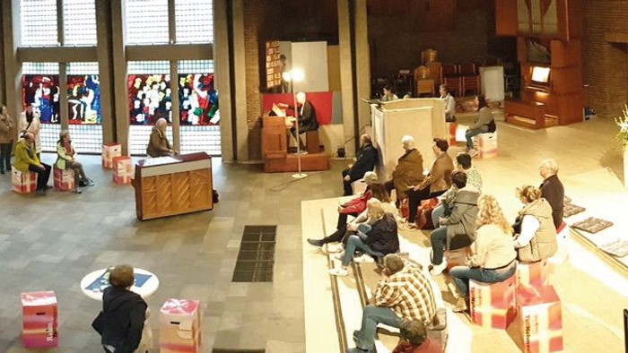 Viele Menschen auf einem großen Marktplatz mit Ständen und Tischen.