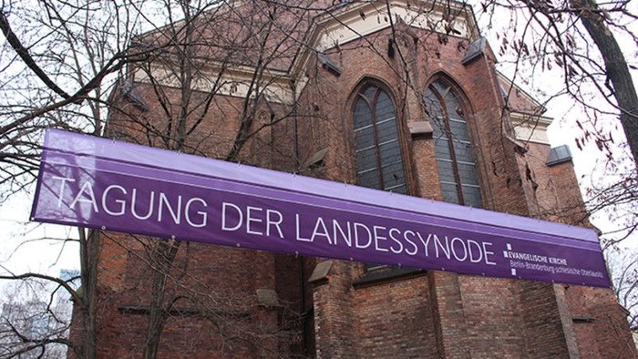 Buntes Banner vor alter Kirche