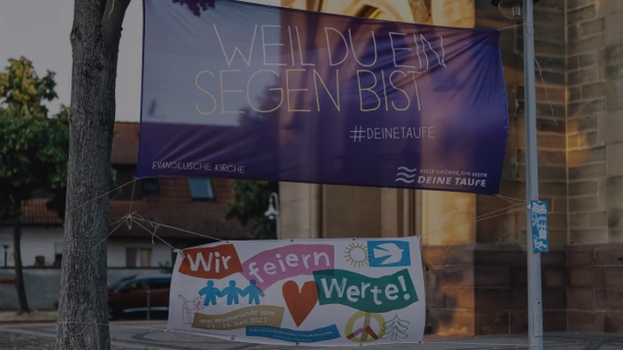 Bunte Banner mit Begrüßung und Werbung an Laterne