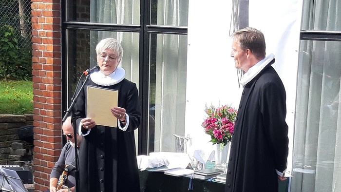 To nonner udfører en ceremoni ved et vindueskarm