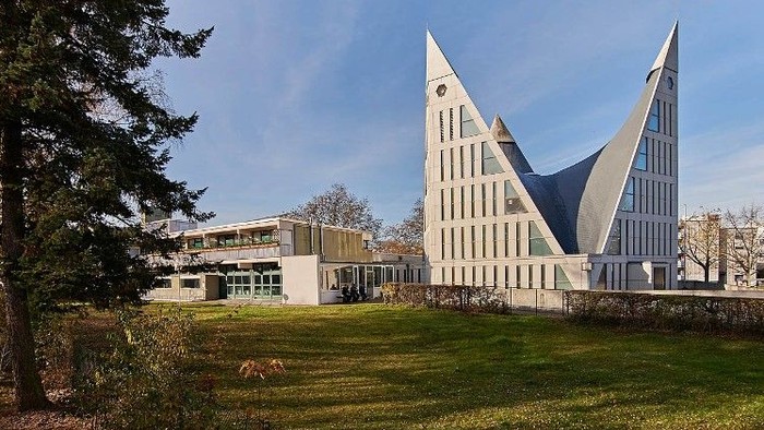 Modernes Gebäude mit markanter Architektur auf grünem Gelände