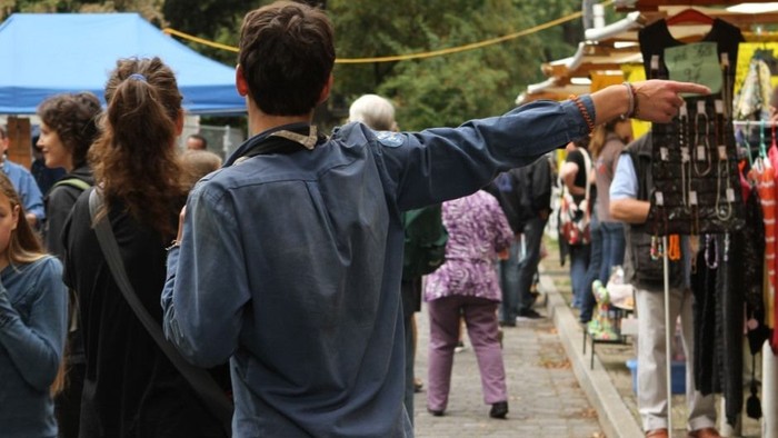 Mann und Frau auf belebten Markt, er zeigt auf etwas