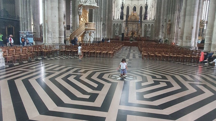 Großzügige Kathedrale mit schwarz-weißem Bodenmuster und hohen Säulen.