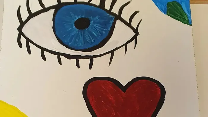 Das Bild zeigt ein Auge und ein Herz auf einem Blatt Papier