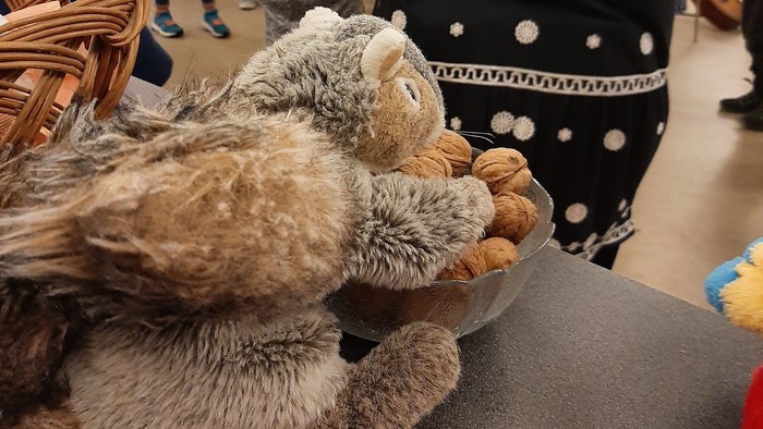 Frau mit Katzen-Teddybären auf dem Arm in belebter Umgebung