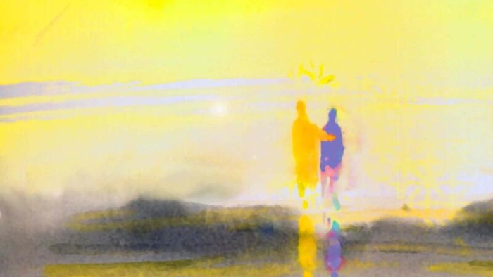 Zwei Personen gehen am Strand bei Sonnenuntergang