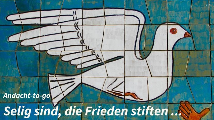 Ein weißer Friedenstaube auf blauem Hintergrund mit dem Spruch "Andacht-to-go Selig sind, die Frieden stiften..."