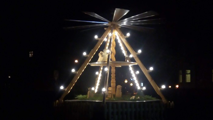 Ein beleuchteter Weihnachtsstern auf einem Sockel bei Nacht