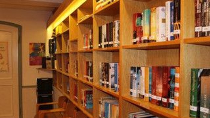 Ein Bücherregal mit vielen Büchern und einer Holzkonstruktion.