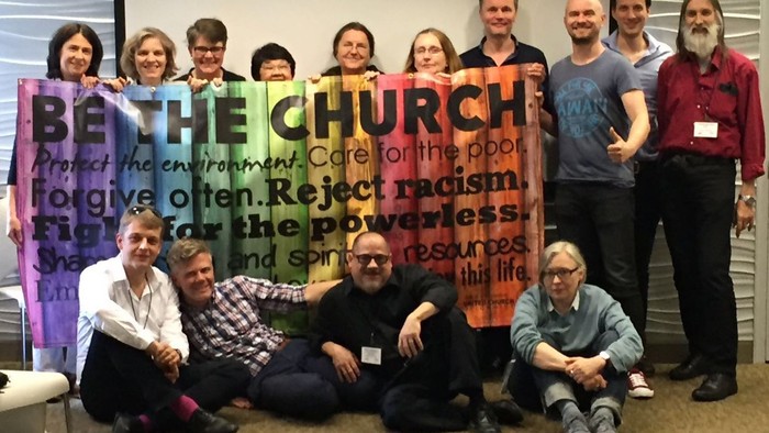 Eine Gruppe von Menschen hält ein Banner mit der Aufschrift
