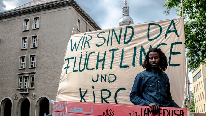 Person hält Protestschild mit Aufdruck