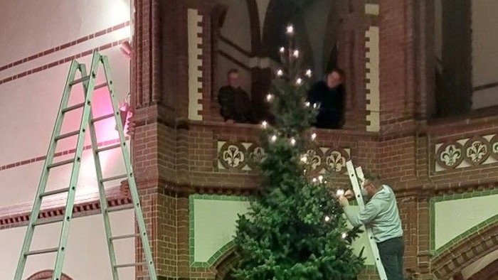 Weihnachtsbaum wird in Kirche geschmückt